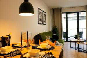 a living room with a dining room table with plates and glasses at Justinrent PALATIUM 12 in Legnica +15 photos