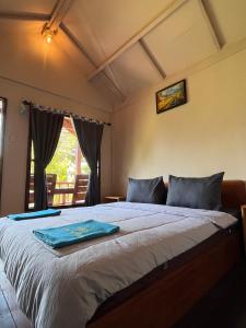 a bedroom with a bed with a blue towel on it at Haris Homestay & Cottages in Senaru