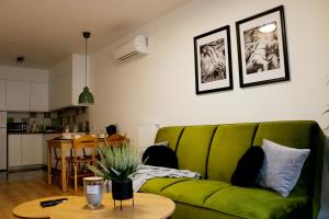 a living room with a green couch and a table at Justinrent PALATIUM 12 in Legnica