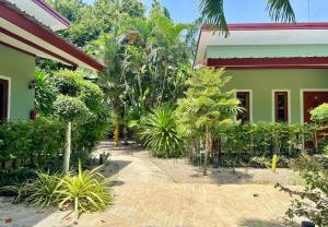 un jardín junto a un edificio con palmeras en AJ Paradise Resort Aonang Krabi, en Ao Nang Beach