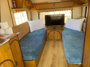 a living room with a couch and a tv in an rv at KAroo Rustic caravan in Ladismith