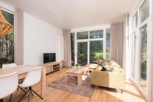 a living room with a table and a couch at River Cabin with bubbeltub 6 people in Zuna