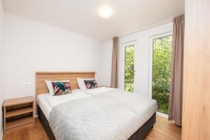 a bedroom with a large bed and a window at River Cabin with bubbeltub 6 people in Zuna