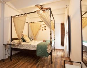 a bedroom with a canopy bed with a fan at Casa Rural de Benitandus in Alcudia de Veo