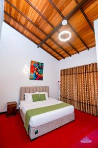 a bedroom with a large bed and a red carpet at Prabhaz Grand in Hatton