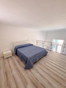 a bedroom with a bed with a blue blanket on it at Il Balcone sul Castello in Ischia