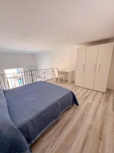 a bedroom with a bed and a wooden floor at Il Balcone sul Castello in Ischia +15 photos