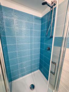 a bathroom with a shower with blue tiles at Il Balcone sul Castello in Ischia