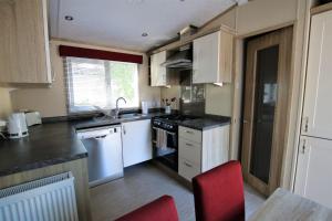 a kitchen with white cabinets and a stove top oven at Harbourside in Christchurch