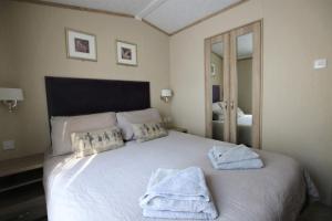 a bedroom with a white bed with towels on it at Harbourside in Christchurch