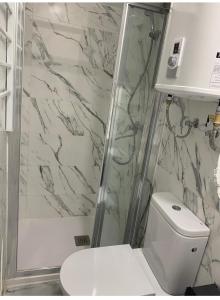 een badkamer met een wit toilet en een douche bij Casa Duque in Madrid