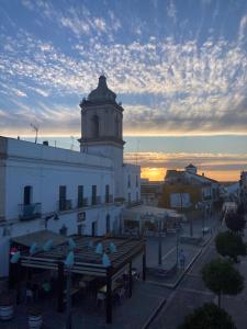 a white building with a clock tower on top of it at Apartamento Estrella Sol in Cartaya