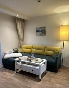 a living room with a couch and a coffee table at Chamkoria Forest View & Spa Apartment in Borovets