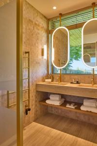 a bathroom with two sinks and two mirrors at Le Rêve - Hôtel Luxe in Mesnil-Saint-Père