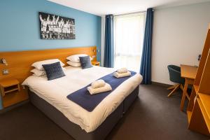 a bedroom with a large bed with towels on it at Bisham Abbey National Sports Centre in Marlow