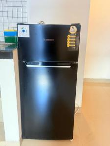 a black refrigerator is sitting in a kitchen at Home Stay Room in Bali Near Sanur Beach in Sanur