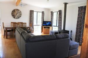 un soggiorno con divano e sala da pranzo di Sea'Renity Cottage a Venus Bay