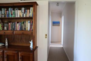 un corridoio con una libreria piena di libri di Sea'Renity Cottage a Venus Bay Altre 8 foto