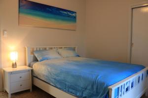 una camera da letto con un letto e un quadro sul muro di Sea'Renity Cottage a Venus Bay