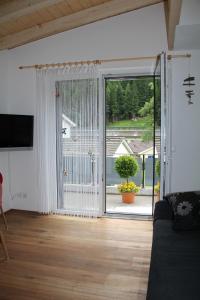 una sala de estar con una gran puerta corredera de cristal en Haus Steiner en Göschenen