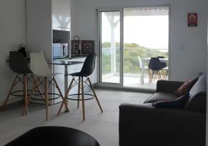 eine Küche und ein Wohnzimmer mit Tisch und Stühlen in der Unterkunft EDEN-RÉSIDENCE Le CURAÇAO Vue Mer et Piscine in Sainte-Luce