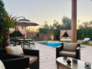 a patio with a table and chairs and a pool at Private Villa BSF - Pool & Spa - Palm Golf in Marrakesh