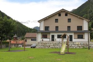 una casa con parco giochi di fronte a un edificio di Haus Steiner a Göschenen