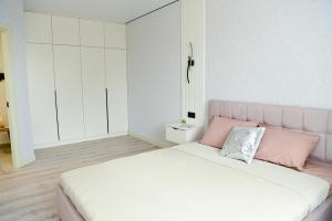 a white and pink bedroom with a pink bed at Яровиця 9 новобуд in Lutsk
