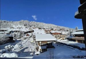 a town covered in snow with a mountain in the background at Les Flanamolo's-Charming apartment luxury complex in Les Gets
