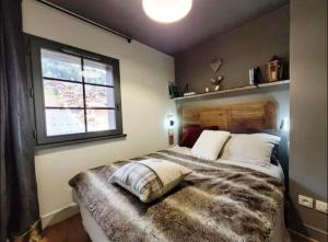 a bedroom with a large bed with a window at Les Flanamolo's-Charming apartment luxury complex in Les Gets +9 photos