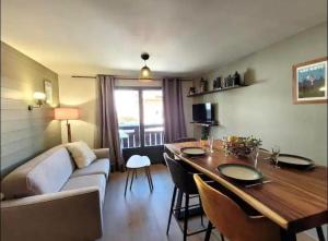 a living room with a couch and a dining room table at Les Flanamolo's-Charming apartment luxury complex in Les Gets