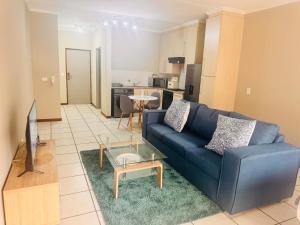 een woonkamer met een blauwe bank en een tafel bij Eden Place in Vosburg