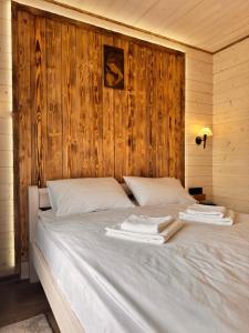 a bed in a wooden room with towels on it at Apartamenty Lisovychok in Richka