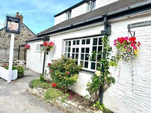 a white building with flowers on the side of it at The Fourways Inn in Saint Minver