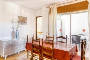 ein Esszimmer mit einem Tisch und einem Fenster in der Unterkunft Apart en Paseo Marítimo 2-3 in Llança