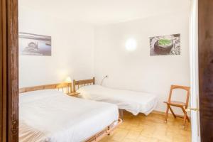 zwei Betten in einem Zimmer mit weißen Wänden in der Unterkunft Apart en Paseo Marítimo 2-3 in Llança