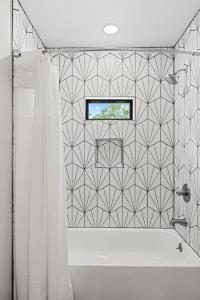 La salle de bains est pourvue d'une baignoire et d'un rideau de douche. dans l'établissement Verbena Waterfront with Hot Tub, à Tivydale