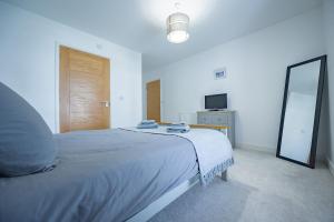 a bedroom with a large bed and a mirror at 2-Bed I Converted Malt House I Rare Find I Parking in Newmarket