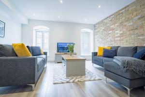 a living room with two couches and a tv at 2-Bed I Converted Malt House I Rare Find I Parking in Newmarket