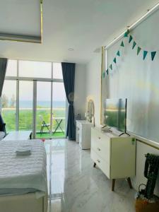 a bedroom with a bed and a dresser with a television at Căn hộ studio view biển hoặc vườn in Ấp Phú Tịnh (2)