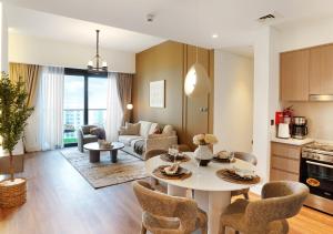 迪拜Chic 2BR in Downtown, 5 Min Walk to Burj Khalifa的配有桌椅的厨房和客厅