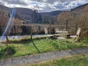 un gruppo di sedie sedute sull'erba di Rustic Welsh cottage a Llanwrtyd Wells