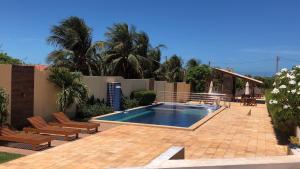 a swimming pool in a patio with chairs at Beautiful house in the paradise of São Cristóvão RN in Areia Branca