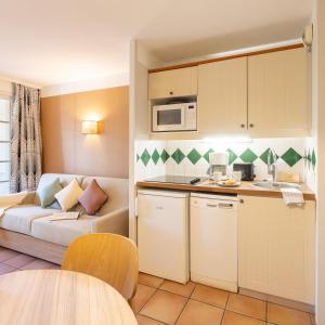 a small kitchen and living room with a couch at Résidence Pierre & Vacances La Villa Maldagora in Ciboure