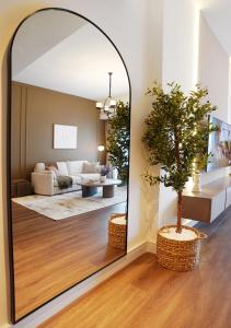 迪拜Chic 2BR in Downtown, 5 Min Walk to Burj Khalifa的客厅里有一面大镜子，旁边还有一棵树
