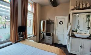 a bedroom with a bed and a sink and a mirror at De Juttershoek Centrum in Kampen +25 photos