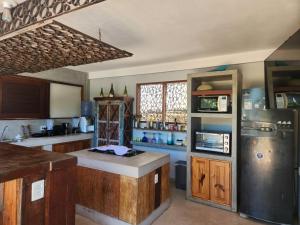 una cucina con mobili in legno e un frigorifero in acciaio inossidabile di Casa Leque - Praia da Pipa - Centro a Pipa
