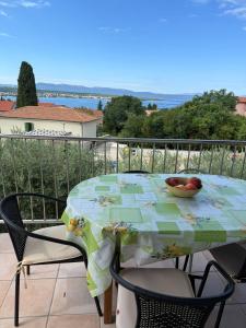 a table with a bowl of fruit on top of a balcony at Großzügige 6-Personen Ferienwohnung in Kroatien in Malinska