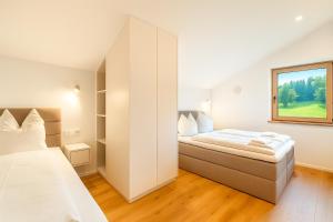 a bedroom with two beds and a window at Berg I Sauna I Balkon I See-Bergblick I Biohof in Rieden am Forggensee