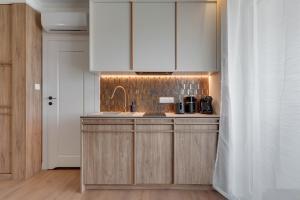 a kitchen with white cabinets and a sink at Perspektywa Apartment with balcony by Lion Apartments in Gdańsk